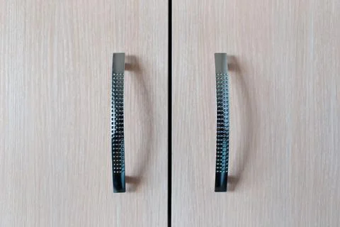 Close-up detail picture of metal knobs, of pastel beige cupboard. Foto stock