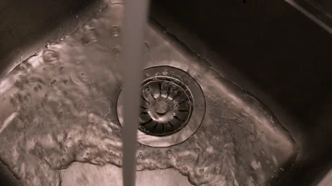 Close up detail: Stream of water flows from tap in steel kitchen sink Stock Footage 265570027