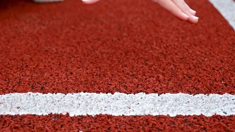 Close detail of track runners putting hands at starting line Stock Footage