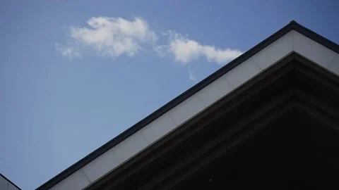 Close-up, detail of triangular roof of building against blue sky on sunny day Stock Footage 147093293