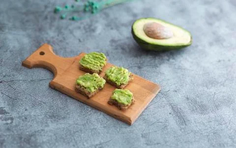 Close up detail view of avocado bread bites over rustic backdrop Foto stock