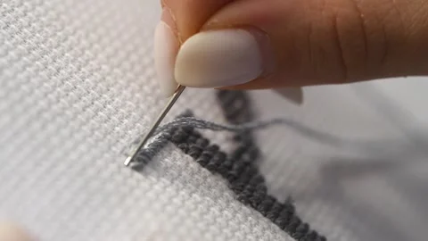Close up detailed process of black cross stitch embroidery on white fabric .. Stock Footage 334955273