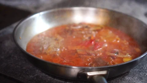 Close up detailed view on hot steaming vegetable stew simmering in steel frying Stock Footage 106815483