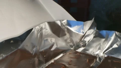 Close up. details of dark chocolate with nuts on silver foil Stock Footage 135877045