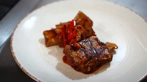 Close up details of delicious slices of fried meat pork ribs in hot spicy sauce Stock Footage 106979188