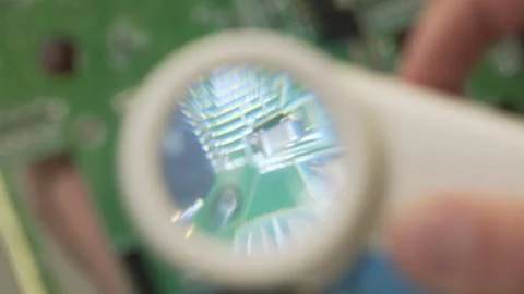 Close-up details of an electronic board through a magnifying glass. 스톡 동영상 332533468