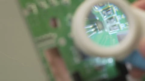 Close-up details of an electronic board through a magnifying glass. Stock Footage 333514892