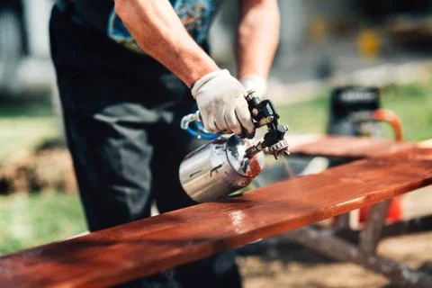 Close-up details of man using spray gun or airbrush for painting  fence. Stock Photos