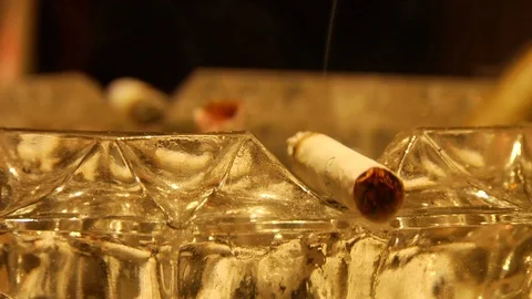 Close Up Details of unfiltered cigarette burning in crystal ashtray Stock Footage 106938025