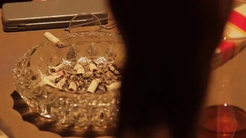 Close Up Details of unfiltered cigarette snubbed out in crystal ashtray Stock Footage 106946400
