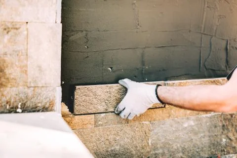 Close up details of worker hands using cement and mortar and installing stone Stock Photos