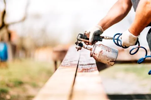 Close up details of worker hands using airbrush and spray gun for painting Stock Photos