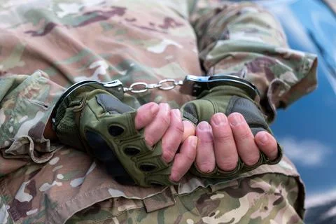 Close up of a detained serviceman's hands in tactical gloves and camouflage.. Fotos de archivo