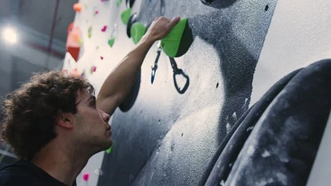 Close-Up of a Determined Climber Reaching for a Handhold on an Indoor Climbing Stock Footage 278732881