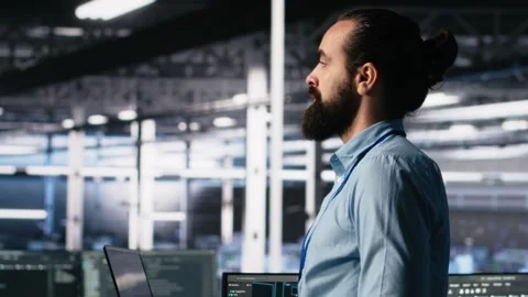 Close up of developer in data center coding with generative AI on laptop Stock Footage 313566249