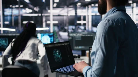 Close up of developer in data center coding with generative AI on laptop Stock Footage 313637010