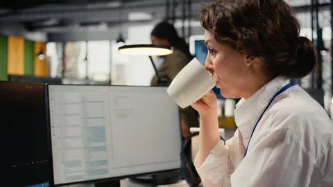 Close up of developer drinks coffee while working in AI startup 스톡 사진
