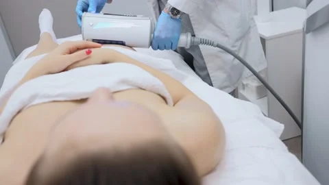 Close-up of the device massaging the buttocks and legs of a young woman. The Stock-Footage 231073141