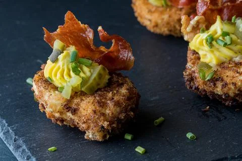A close up of a deviled egg appetizer garnished with crispy prosciutto. Stock Photos
