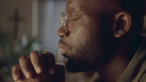 Close-Up of Devout Black Man Praying to God during the Evening at Home Video stock 287772836