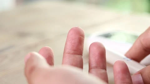 Close up diabetic test using lancet pen ad glucometer on finger with blood drop Stock Footage 156479598
