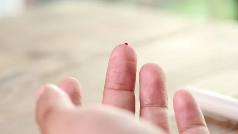 Close up diabetic test using lancet pen ad glucometer on finger with blood drop Stock Footage 156479856