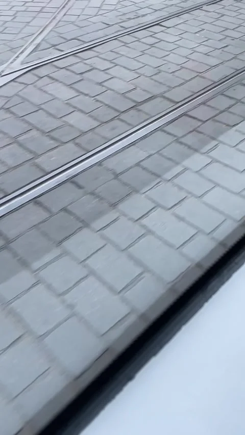 Close-up diagonal view of tram rails through wet paved street Stock Footage 341671890