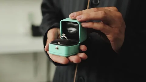 Close-up of a diamond engagement ring held by a man. A man proposes with an Stock-Footage 323376656
