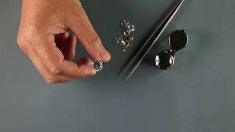 Close up of diamond expert hand examines round cut diamond at workplace. Top Video stock 156010953