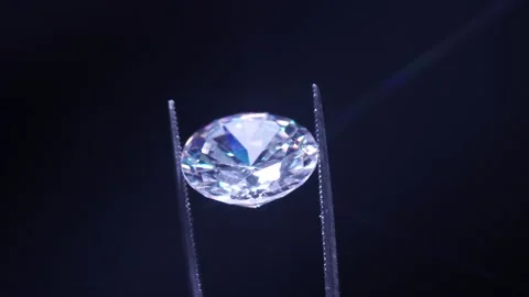 Close up of diamond held in tweezers, selective focus. View under magnifying  Stock Footage