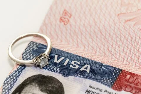 Close-up of a diamond ring on a US visa as an idea for a marriage move Stock Photos