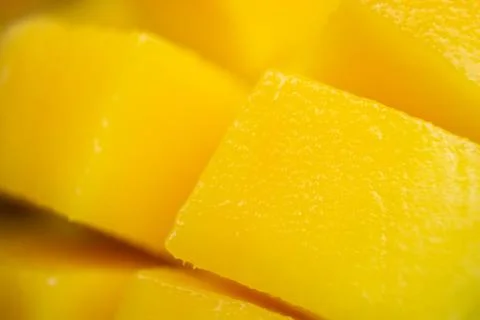 Close up dice yellow mango cut into cubes. Macro shot background. Rip exotic Stock Photos