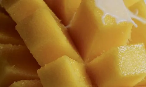 A close-up of diced mango. The fruit is bright yellow and juicy Stock Photos