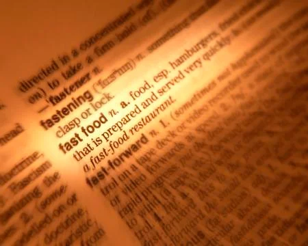 CLOSE UP OF DICTIONARY PAGE SHOWING DEFINITION OF THE WORDS FAST FOOD Foto stock