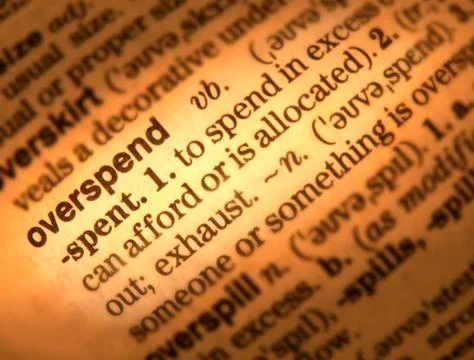CLOSE UP OF DICTIONARY PAGE SHOWING DEFINITION OF THE WORD OVERSPEND Foto stock
