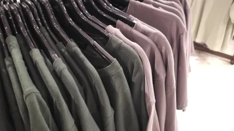 Close-up of different color t-shirts on hangers in a clothing store Stock Footage 283393005