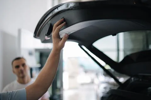 Close-up of different elements car exterior design. Back view of car. Man open Fotos Stock