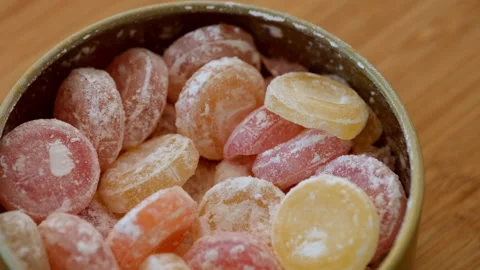 Close-up of different flavours hard drop candies in a tin box. Wooden background Stock Footage 287494212