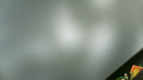 Close-up of different pieces of vegetables is fried and tossed in a pan Stock Footage 113628518