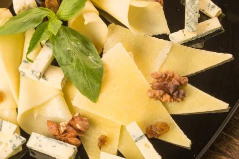 Close up with different types of cheese, on a black plate Stock Photos