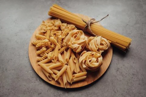 Close Up of Different Types of Pasta and Handful of Spaghetti on the Tray on the Stock Photos
