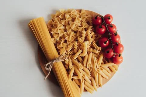 Close Up of Different Types of Pasta and Cherry Tomatoes on the Tray on the Stock Photos
