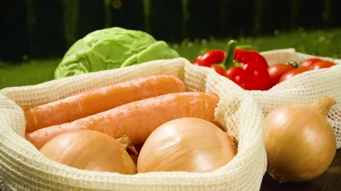 Close-up of different types of vegetables in fabric bags on a wooden table. Stock Footage 276231899