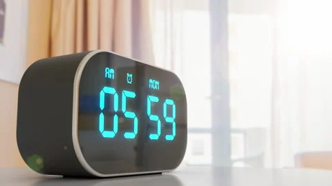 Close-up digital alarm clock against window in the hotel room win sun flare Stock Footage 161412154