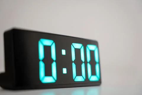 Close up of digital alarm clock at midnight time. Green numbers zero on a black Stock Photos