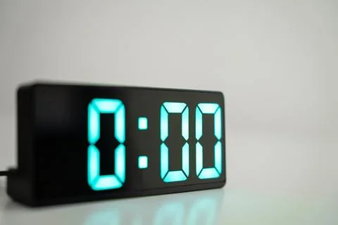 Close up of digital alarm clock at midnight time. Green numbers zero on a black Stock Photos