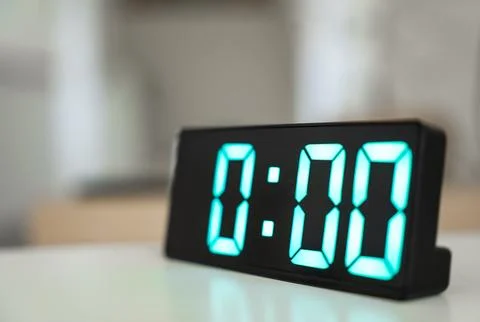 Close up of digital alarm clock at midnight time. Green numbers zero on a black Stock Photos