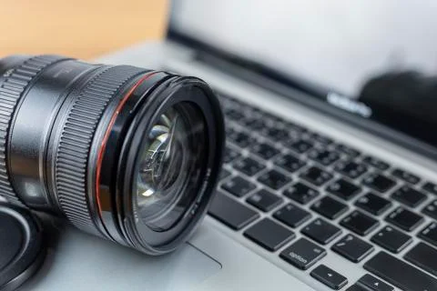 Close up Digital camera len on laptop. Photographic concept Stock Photos