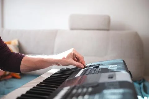 Close-up of a digital keyboard with a hand playing a melody, illuminated by s Foto stock
