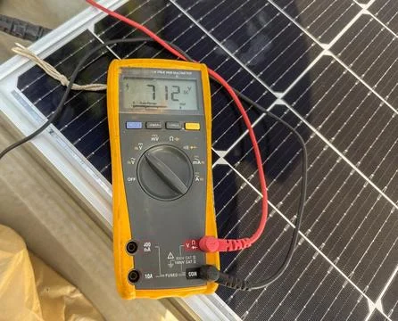 Close-up of a digital multimeter measuring DC voltage output from a photovolt Stock Photos